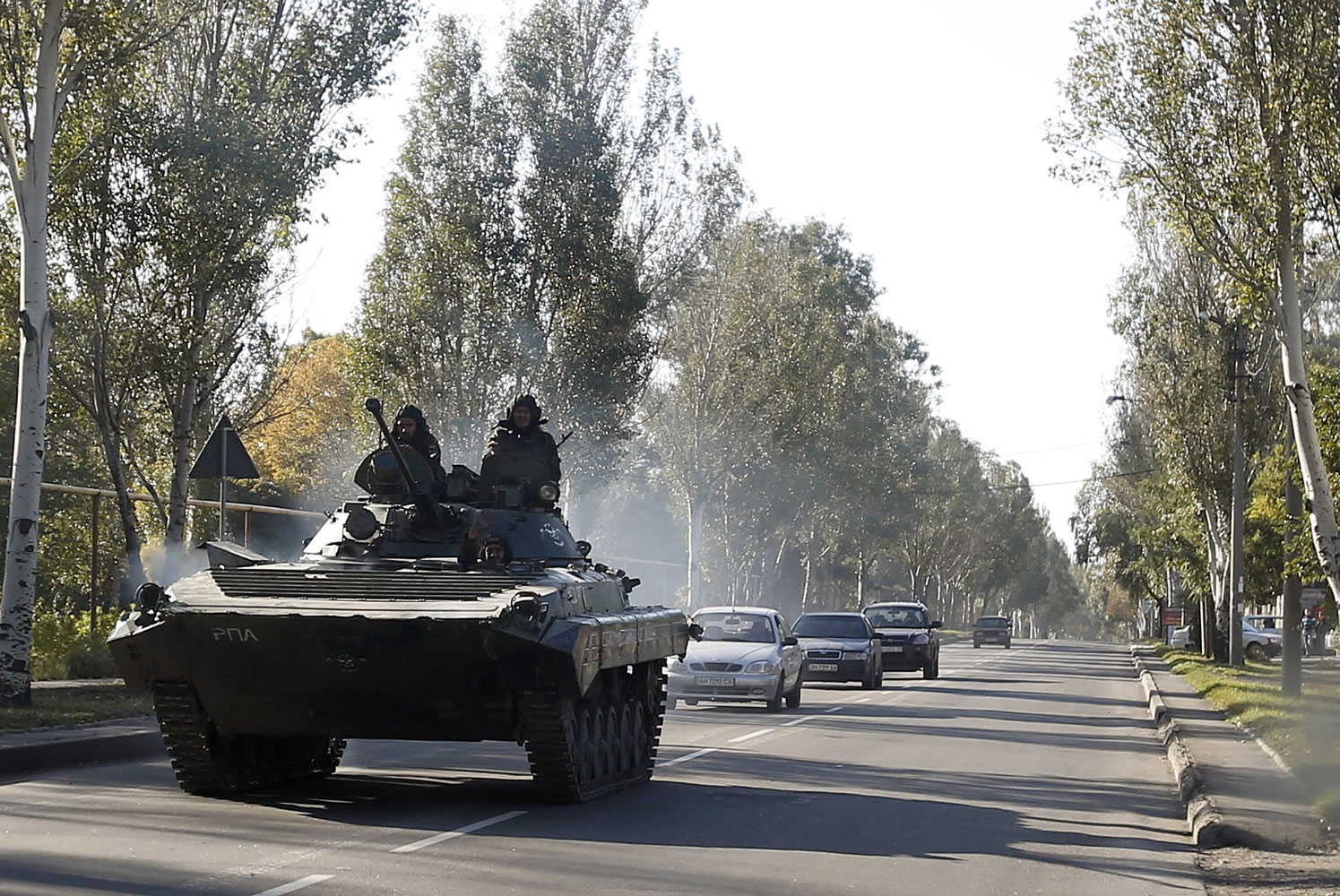 A pro-Russian  armored personal carrier passes through the town of Donetsk, eastern Ukraine, Thursday, Oct. 2, 2014. Pro-Russian rebels in eastern Ukraine advanced Wednesday on the government-held airport in Donetsk, pressing to seize the key transportation hub even as the two sides bargained over a troop pullout under a much-violated truce.