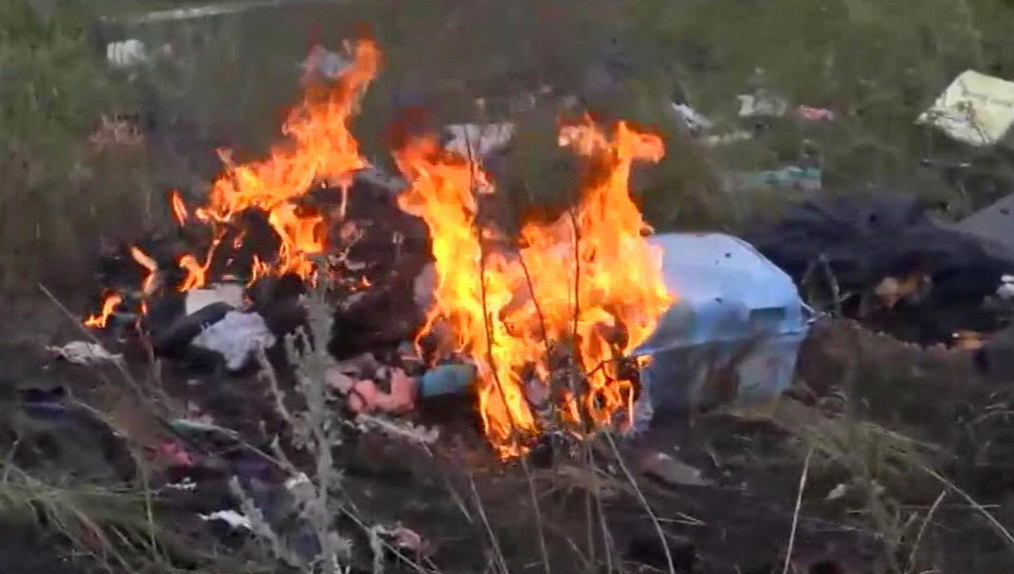 In this image taken from video Thursdayshows flames rising from part of the wreckage of a passenger plane carrying 298 people after it was apparently shot down Thursday as it flew over Ukraine, near the village of Hrabove, in eastern Ukraine.