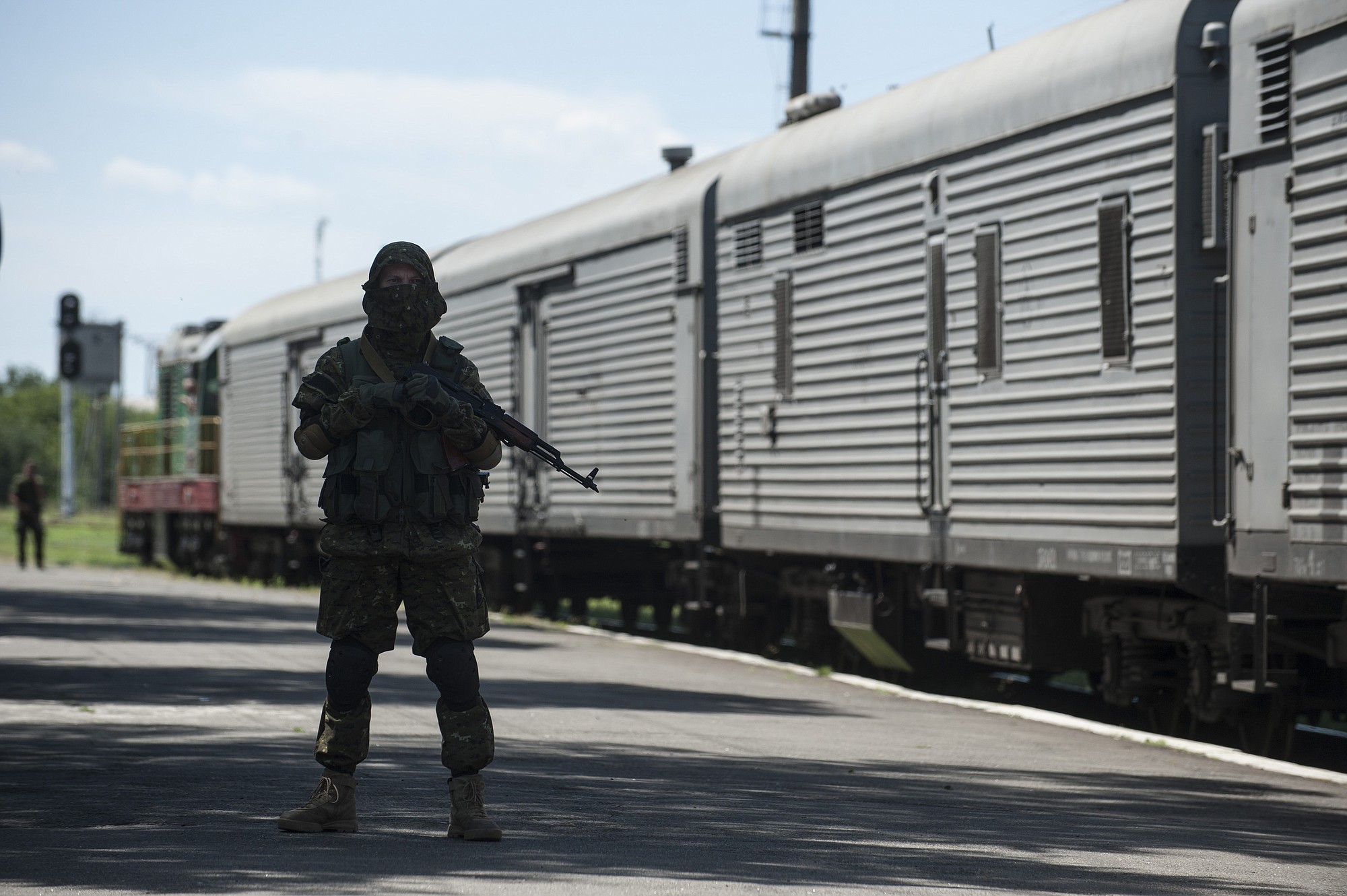 A pro-Russian armed fighter stands in guard on the platform Monday as a refrigerated train loaded with bodies of the passengers departs the station in Torez, eastern Ukraine, 9 miles from the crash site of Malaysia Airlines Flight 17. Another 21 bodies have been found in the sprawling fields of east Ukraine where Malaysia Airlines Flight 17 was downed last week, killing all 298 people aboard.