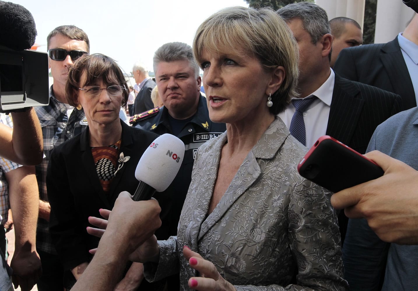 Australian Foreign Minister Julie Bishop, foreground, speaks to the media as a Dutch military cargo plane with coffins holding bodies of some of the passengers of the Malaysia Airlines jetliner which was downed over eastern Ukraine last week, prepares to take off for the Netherlands from Kharkiv airport, Ukraine, on Friday.