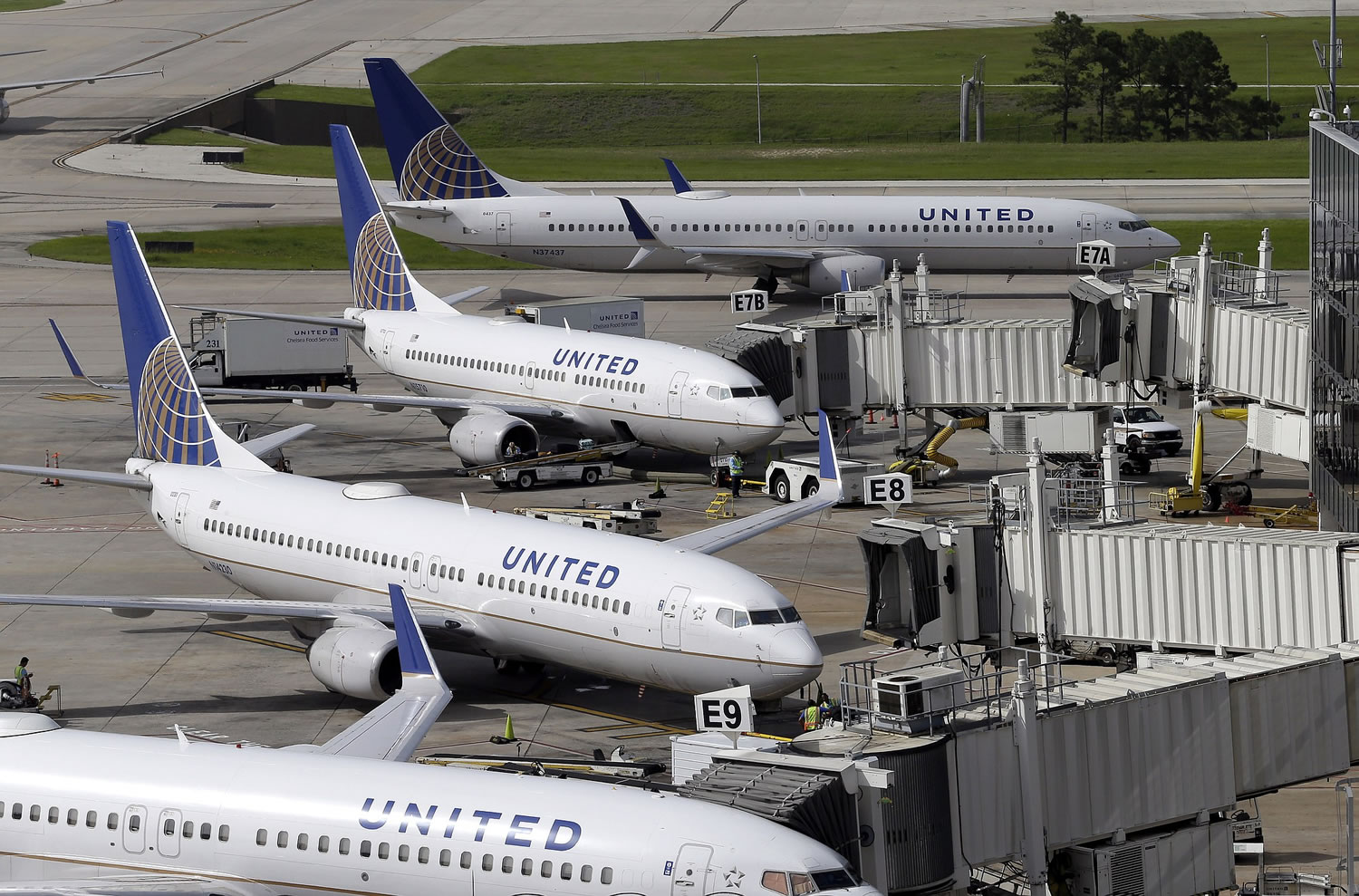 United Airlines planes are parked at their gates as another plane, top, taxis past them at George Bush Intercontinental Airport on Wednesday in Houston. All United Continental flights in the U.S. were grounded temporarily Wednesday due to computer problems. Less than two hours later, United requested the Federal Aviation Administration lift the ground stop order.