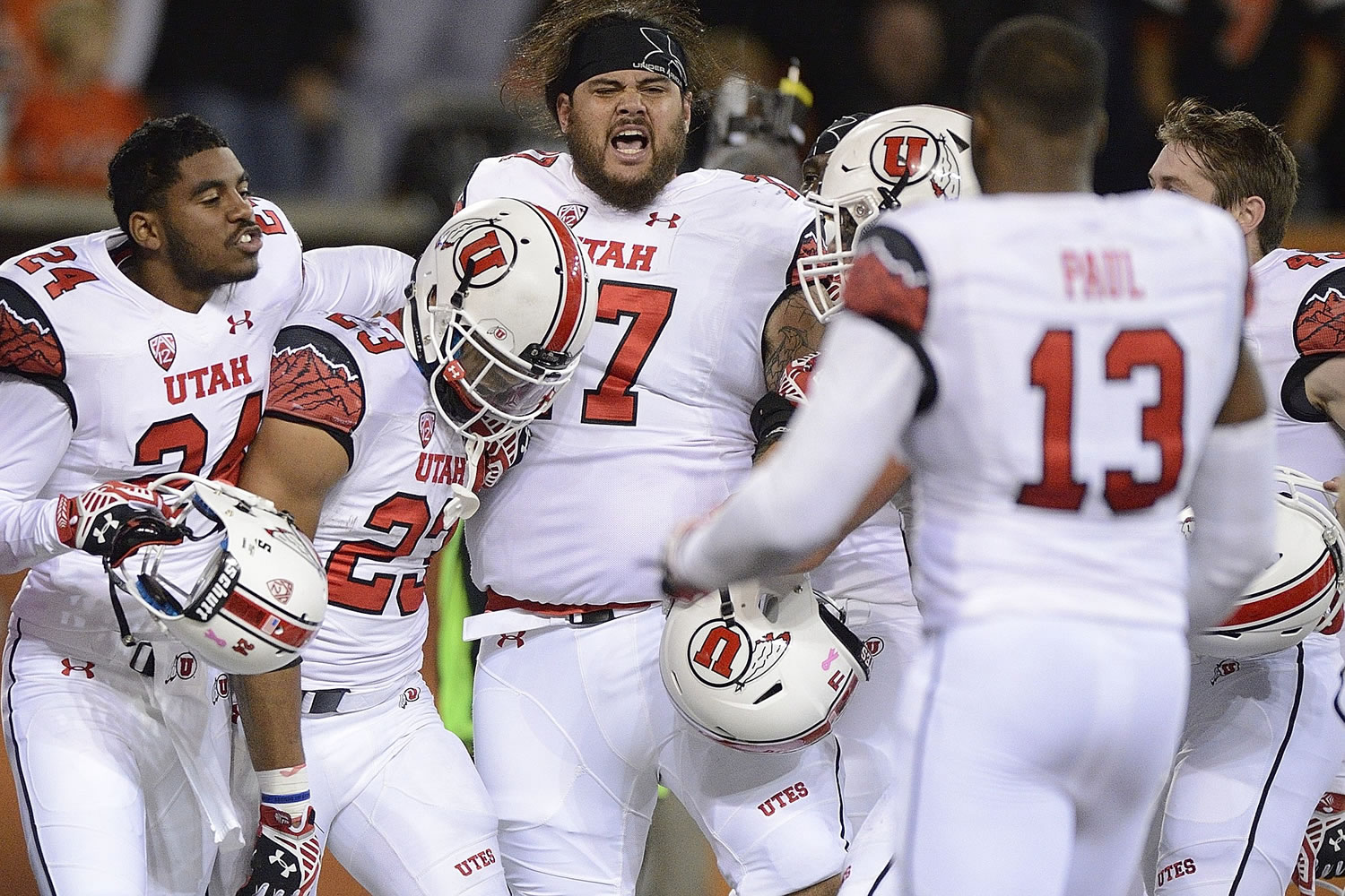 University of Utah running back Devontae Booker (23) celebrates with teammates after scoring a game winning touchdown in overtime against Oregon State on Thursday.