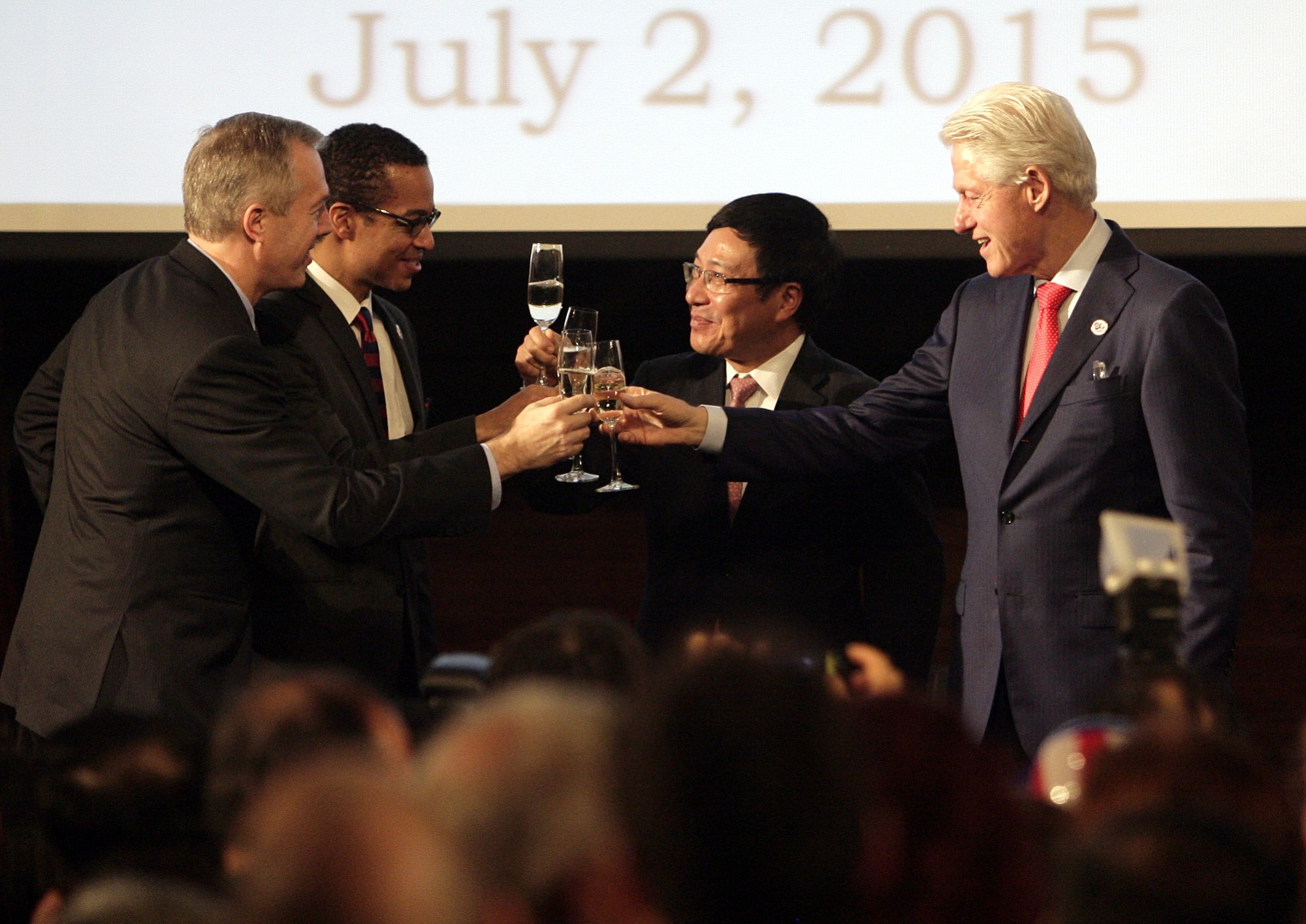 Former U.S. President Bill Clinton, right, Vietnamese Deputy Prime Minister and Foreign Minister Pham Binh MInh, second from right, Clayton Bond, spouse of U.S. Ambassador Ted Osius, third from right and U.S. Ambassador Ted Osius, far left, toast at an event celebrating 239th anniversary of the U.S. independence and 20th anniversary of normalization of relations between the U.S.