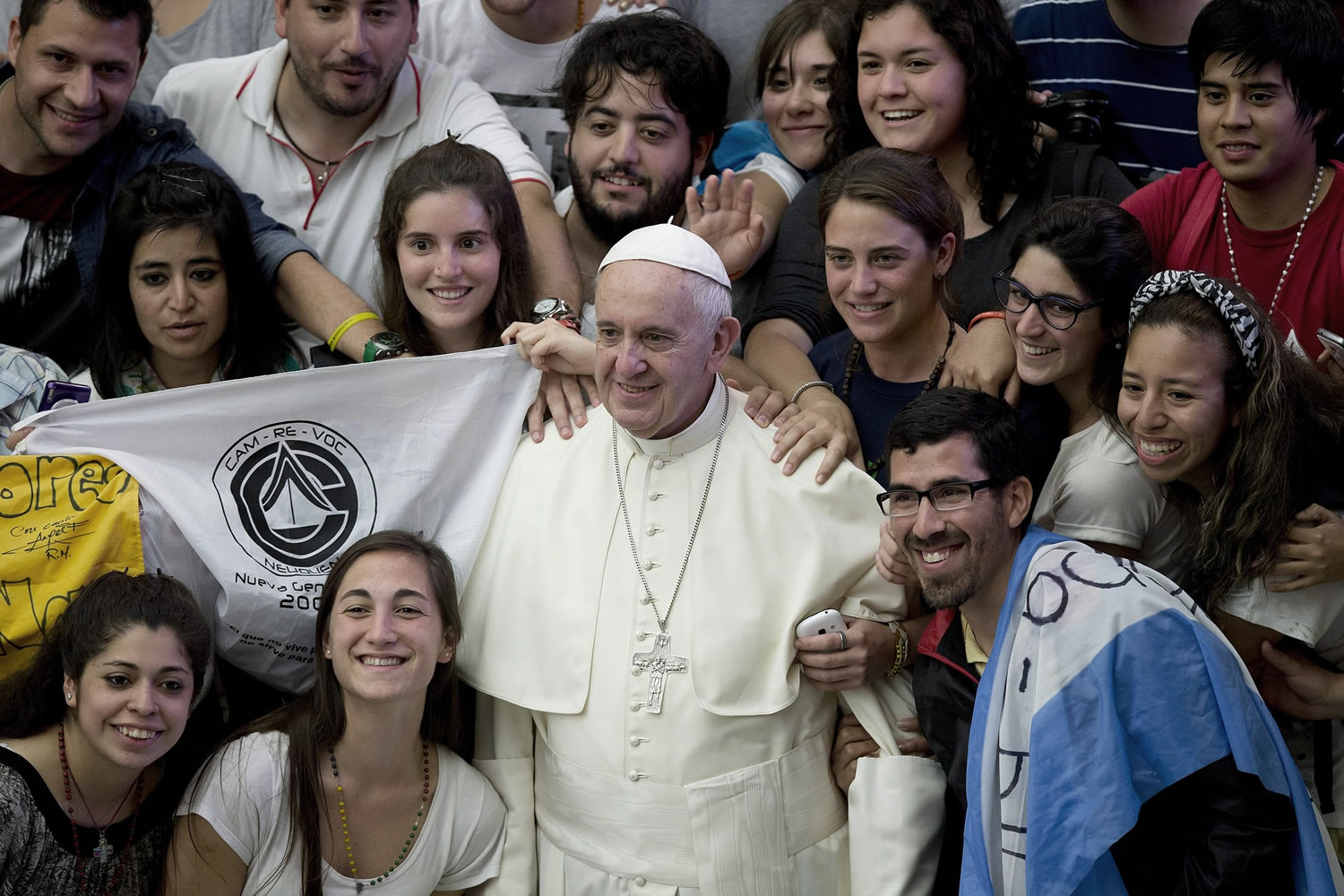 Pope Francis, flanked by pilgrims from Argentina, poses for pictures during his weekly general audience, in the Pope Paul VI hall, at the Vatican on Wednesday.