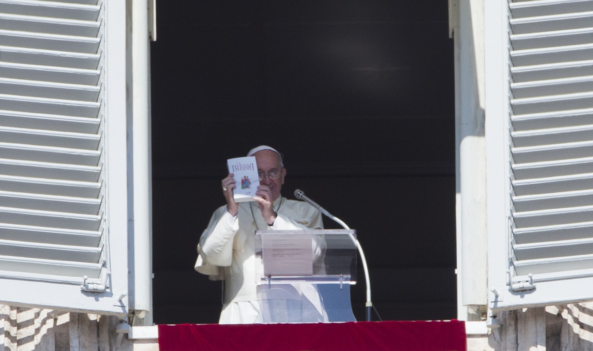 Pope Francis holds up a copy of the Gospel on Sunday during the Angelus prayer in St. Peter's Square at the Vatican.