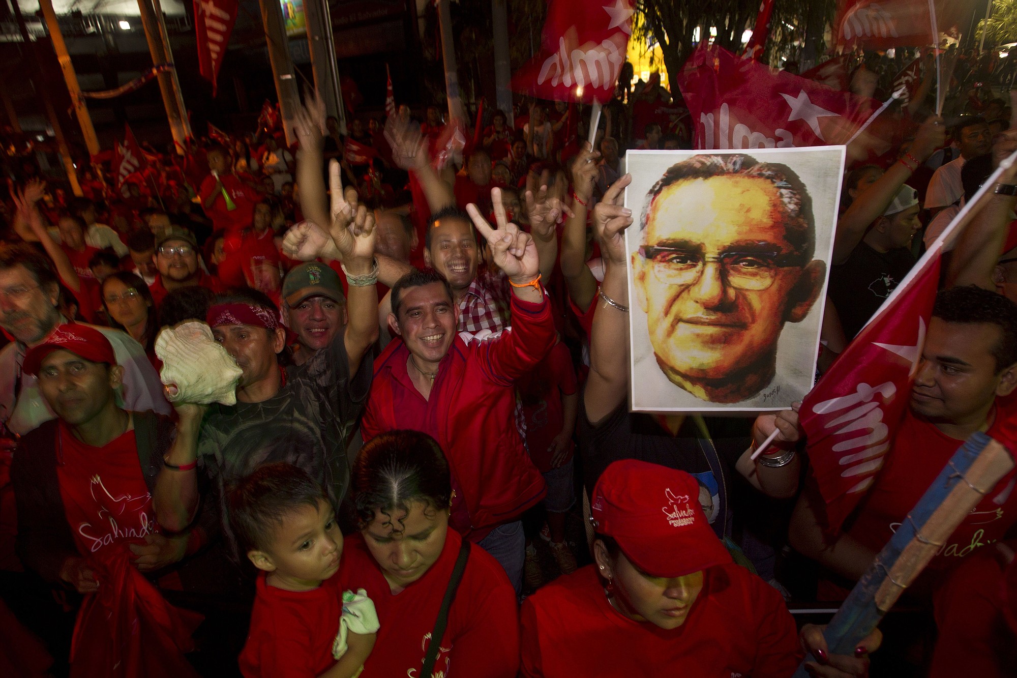 Supporters of presidential candidate Salvador Sanchez Ceren hold up an image of Oscar Arnulfo Romero as they celebrate March 9 after partial results were announced by election authorities in San Salvador, El Salvador.
