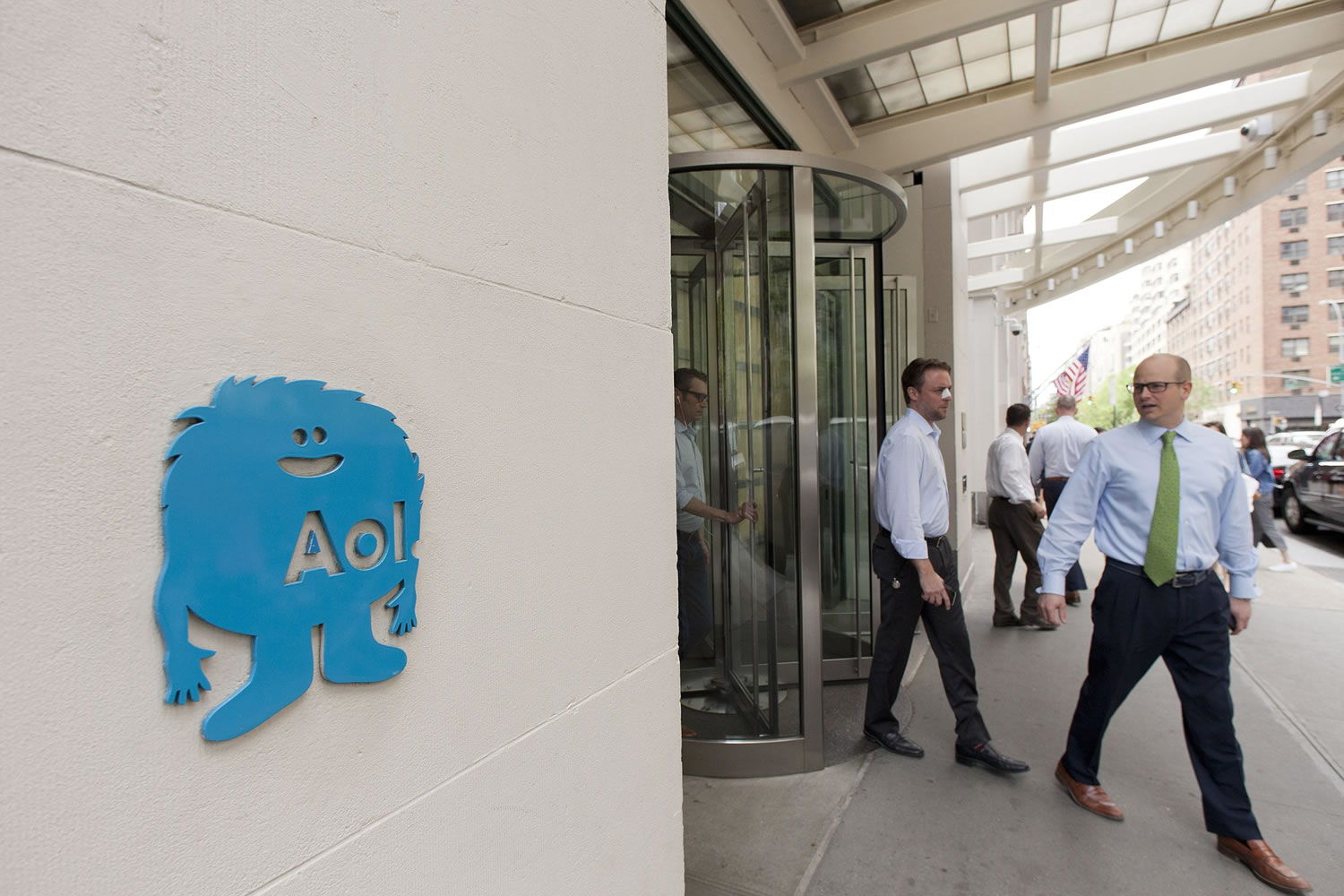 People walk out of the New York office building where AOL headquarters is located, Tuesday, May 12, 2015. Verizon is buying AOL for about $4.4 billion, advancing the telecom's push in both mobile and advertising fields.