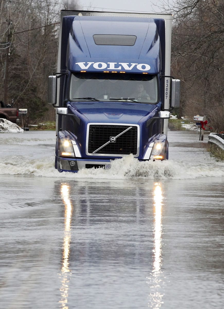 A truck negotiates its way through a flooded Stony Road on Tuesday in Lancaster, N.Y.