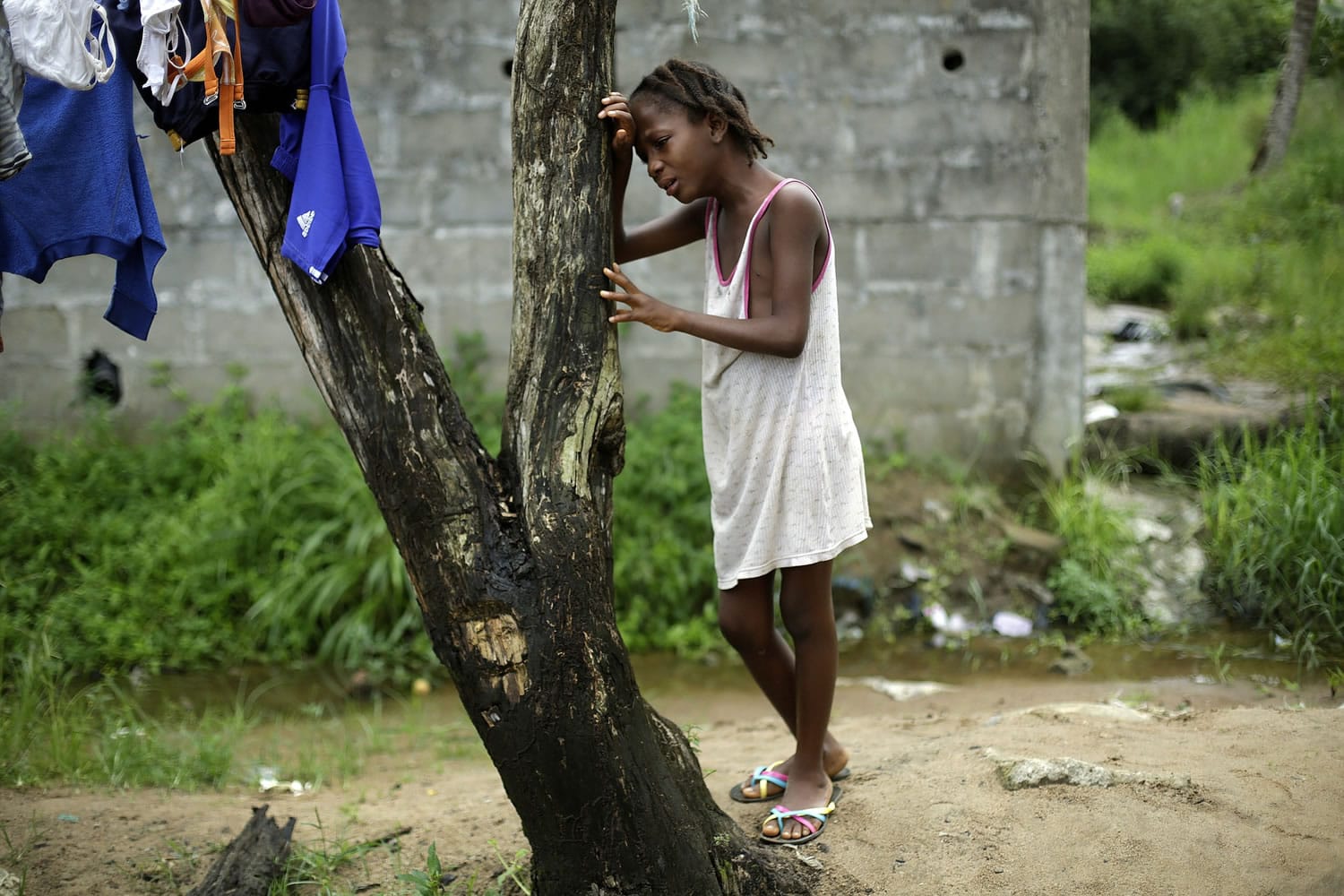 Associated Press files
Mercy Kennedy, 9, cries as community activists approach her outside her home in Monrovia, Liberia, in October a day after her mother was taken away by ambulance to an Ebola ward.