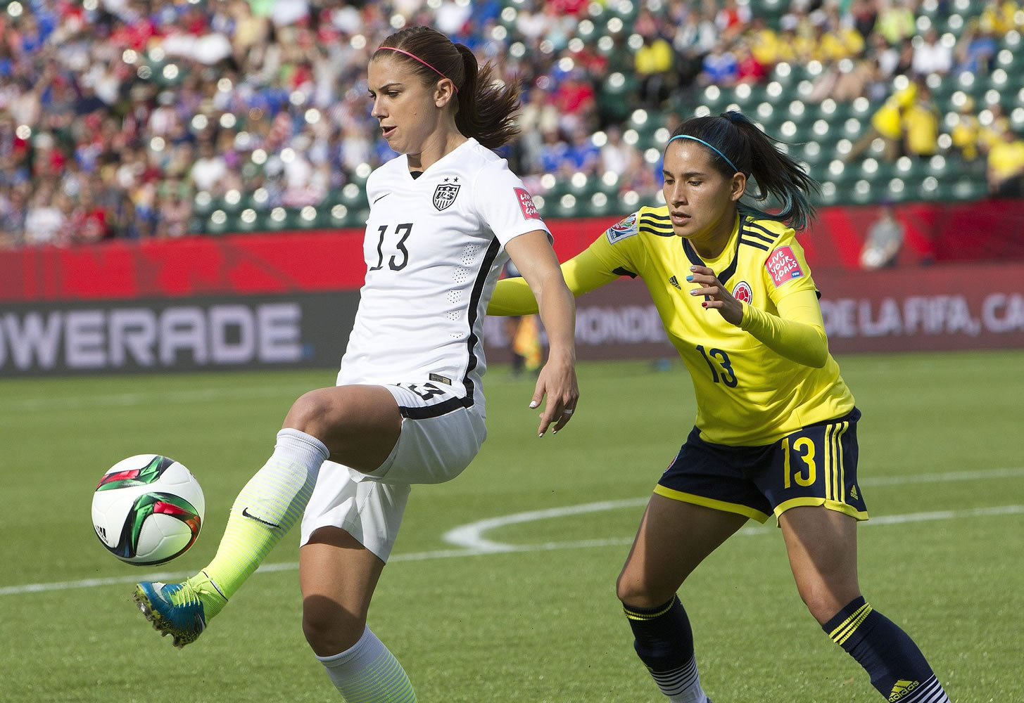 United States' Alex Morgan (13) kicks the ball in front of Colombia's Angela Clavijo (13) during first half in Edmonton, Alberta, Canada, Monday, June 22, 2015.