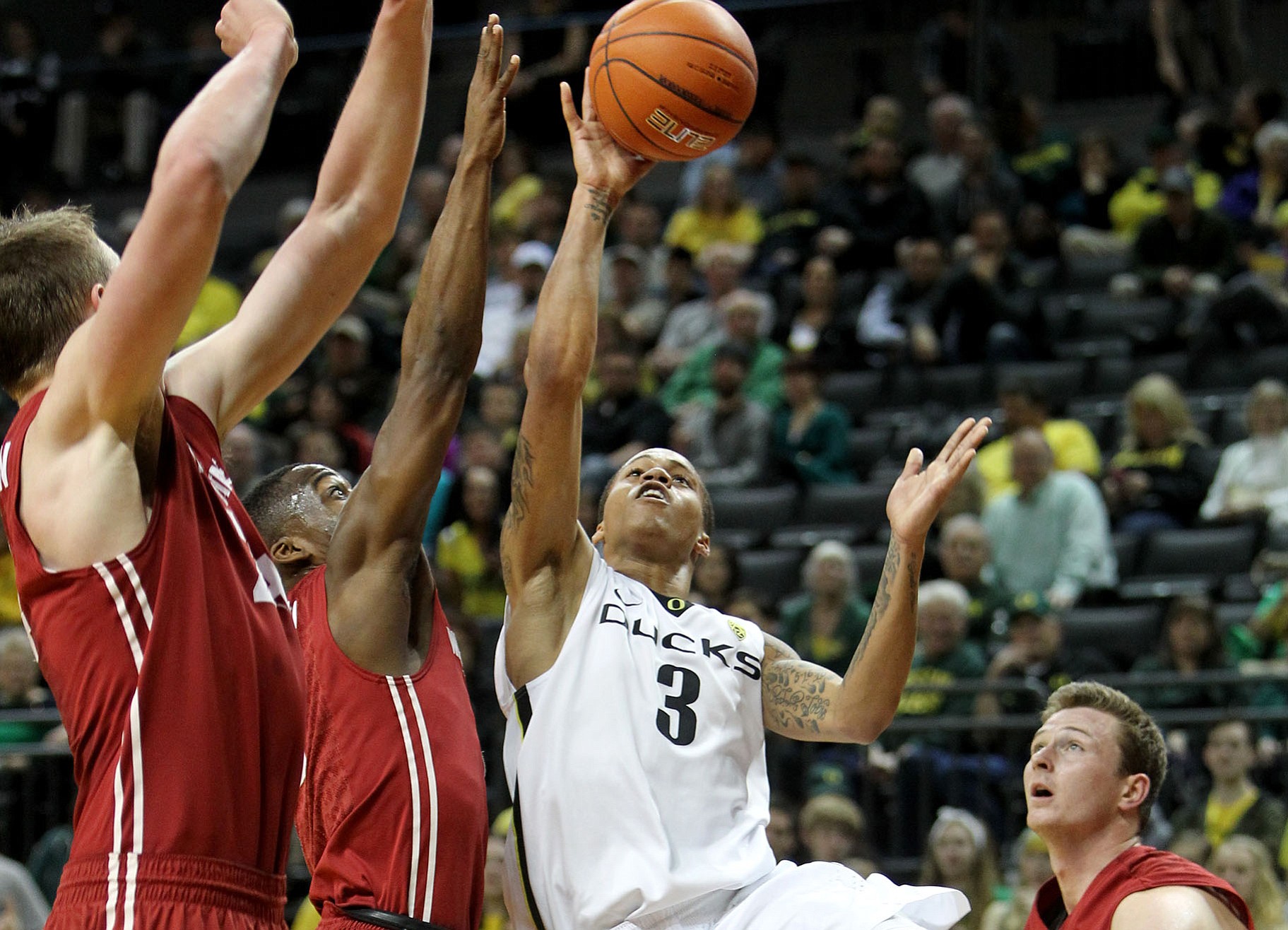 Oregon's Joseph Young, center, shoots against Washington State's Josh Hawkinson, left, Ike Iroegbu and Brett Boese, right, during the first half in Eugene, Ore., Sunday, Feb. 8, 2015.
