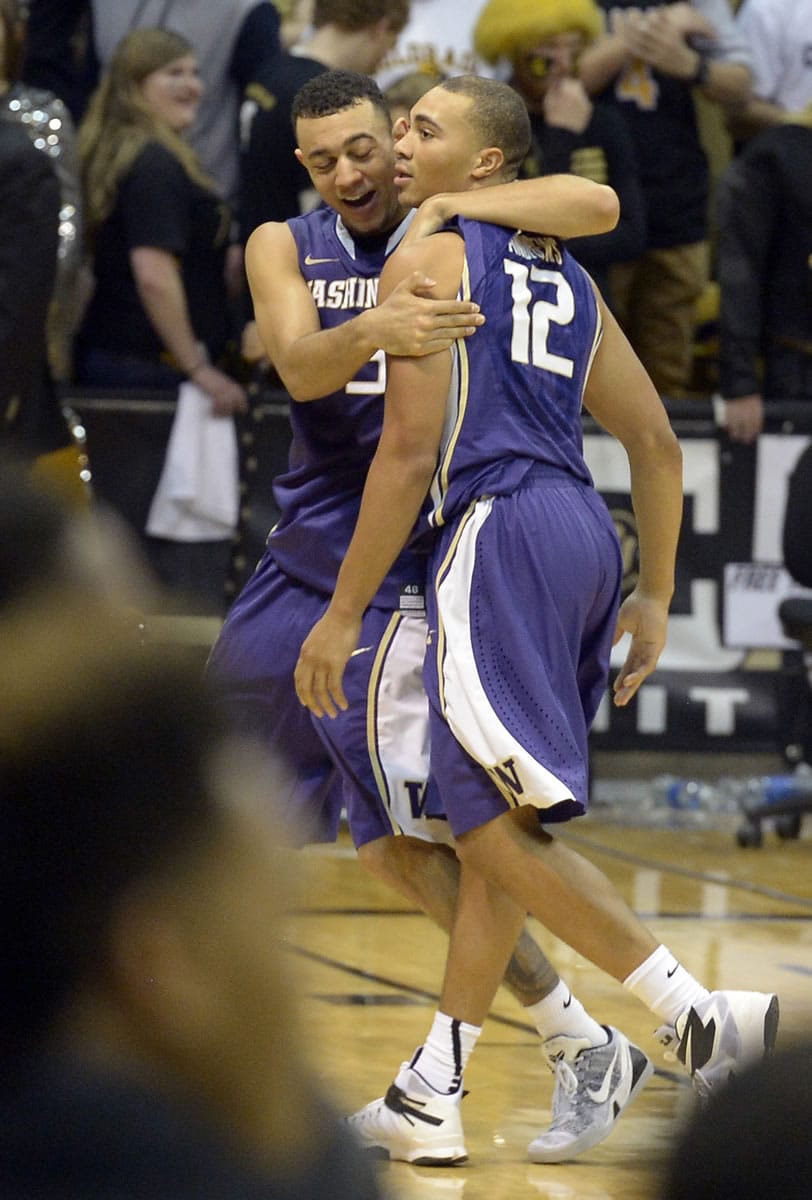 Washington's Nigel Williams-Goss, left, hugs Andrew Andrews after Andrews hit the game-winning shot at the buzzer to defeat Colorado 52-50 on Thursday in Boulder, Colo.