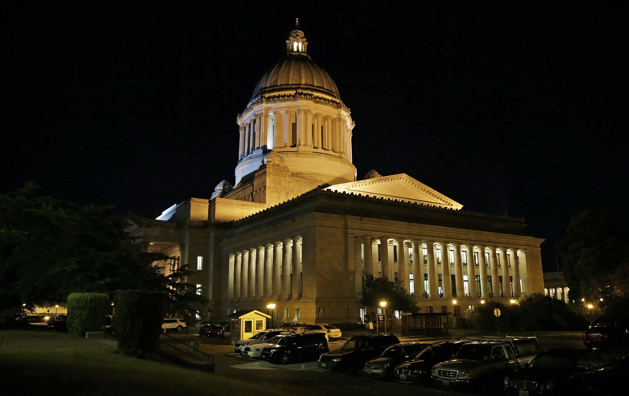 Vehicles remain parked outside the Legislative Building just after midnight, Wednesday at the Capitol in Olympia, as Tuesday's legislative session continued into the night. Washington Gov.
