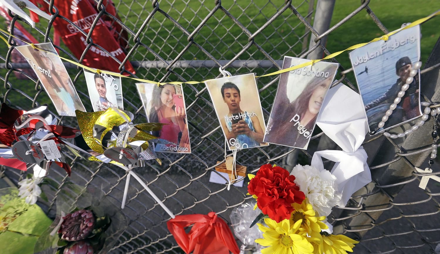 Photos of students shot, and the shooter, are hung together on a fence at Marysville-Pilchuck High School memorializing a shooting there last week, Wednesday in Marysville.