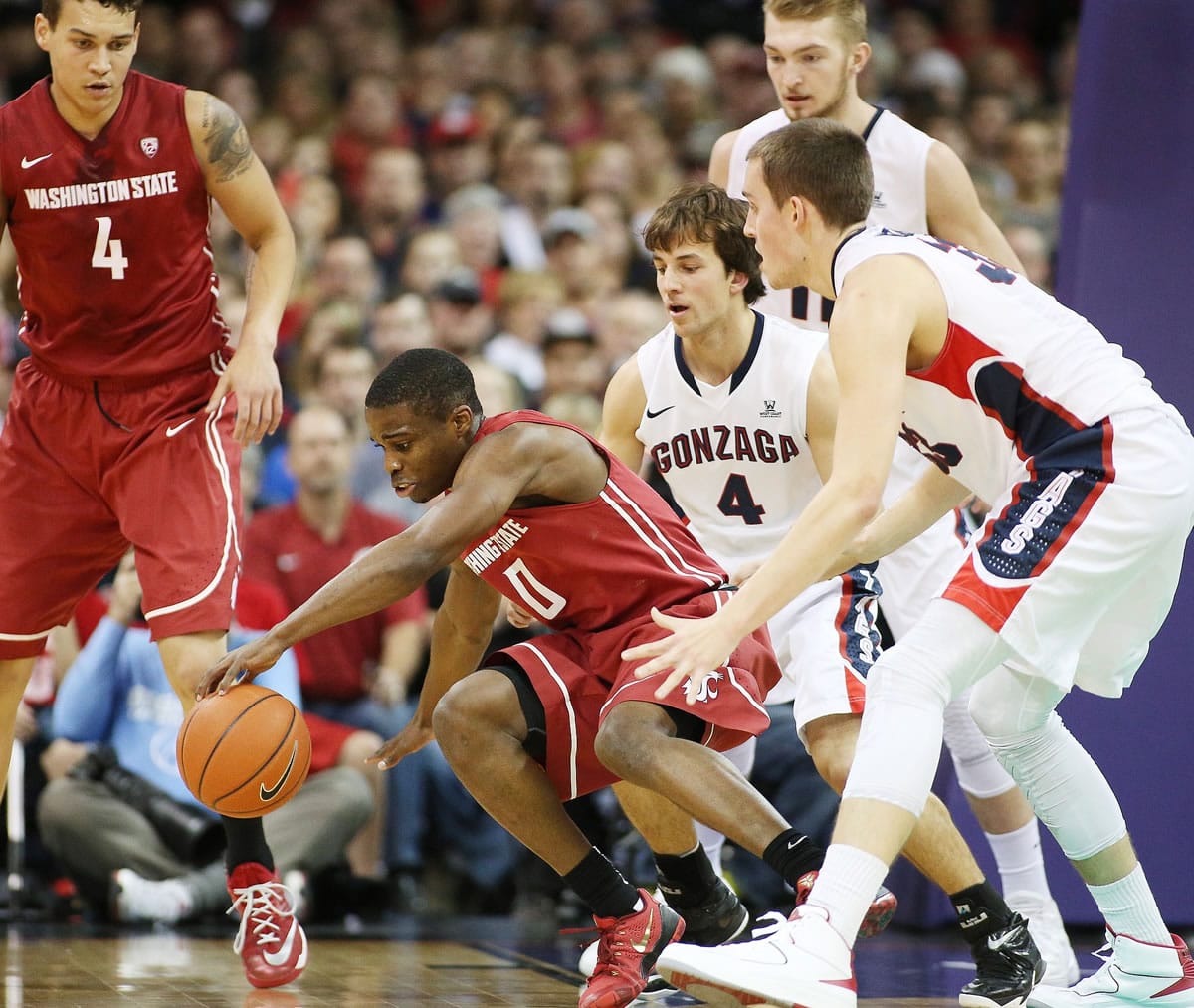 Washington State's Ike Iroegbu (0) goes after a loose ball against Gonzaga's Kyle Wiltjer, right, and Kevin Pangos during the first half in Spokane on Wednesday.