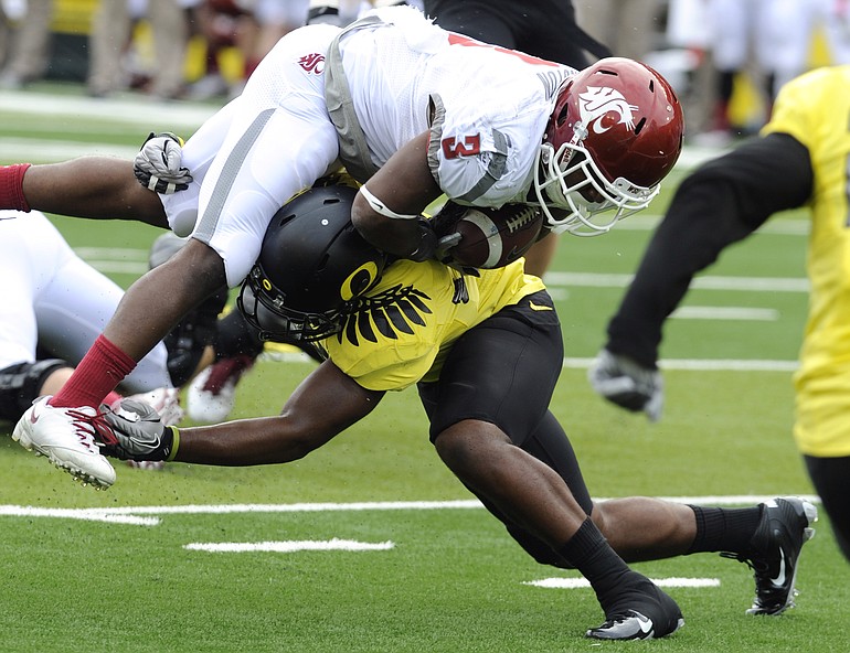 Washington State's Carl Winston (3) is tackled by an Oregon defender in the first half Saturday.