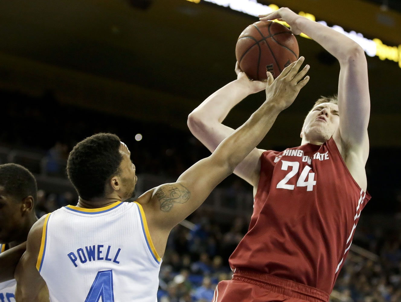 UCLA guard Norman Powell, left, blocks a shot by Washington State forward Josh Hawkinson during the first half in Los Angeles, Sunday, March 1, 2015.
