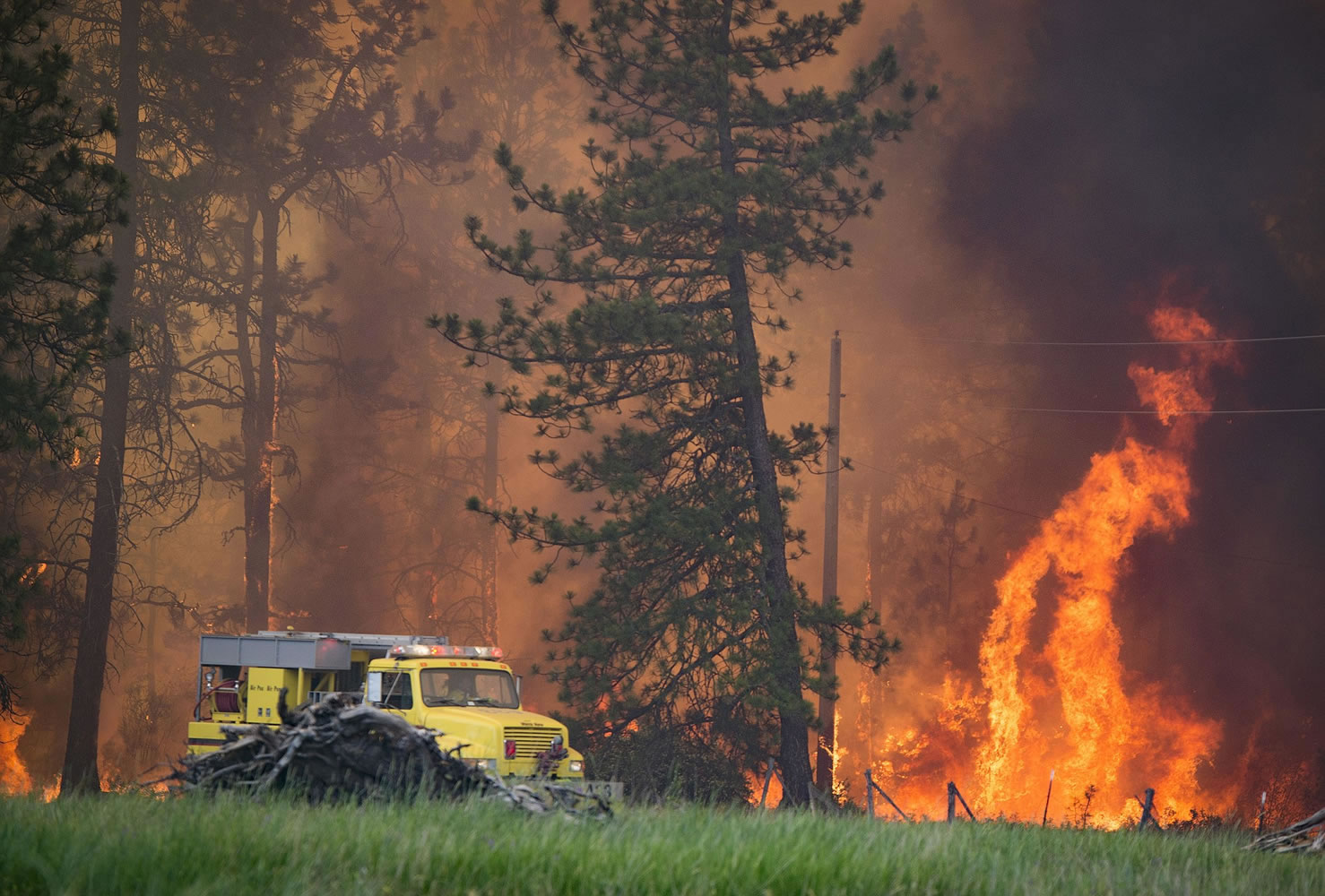 A Spokane County Fire District 3 brush rig works the Fish Lake Fire along Scribner Road on Wednesday.
