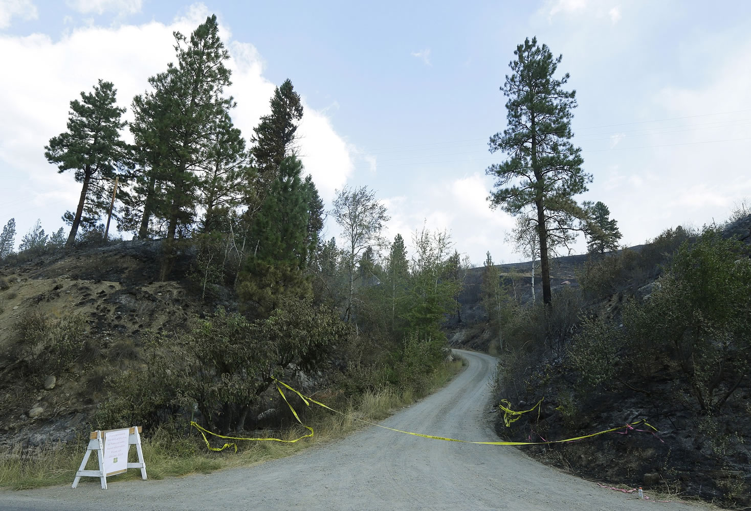 Woods Canyon Road, where three firefighters were killed Aug. 19 while fighting a wildfire near Twisp, is seen Aug. 21. The firefighters died after their engine rushed up a steep gravel road and crashed down a 40-foot embankment. Before they could escape, they were overrun by flames.