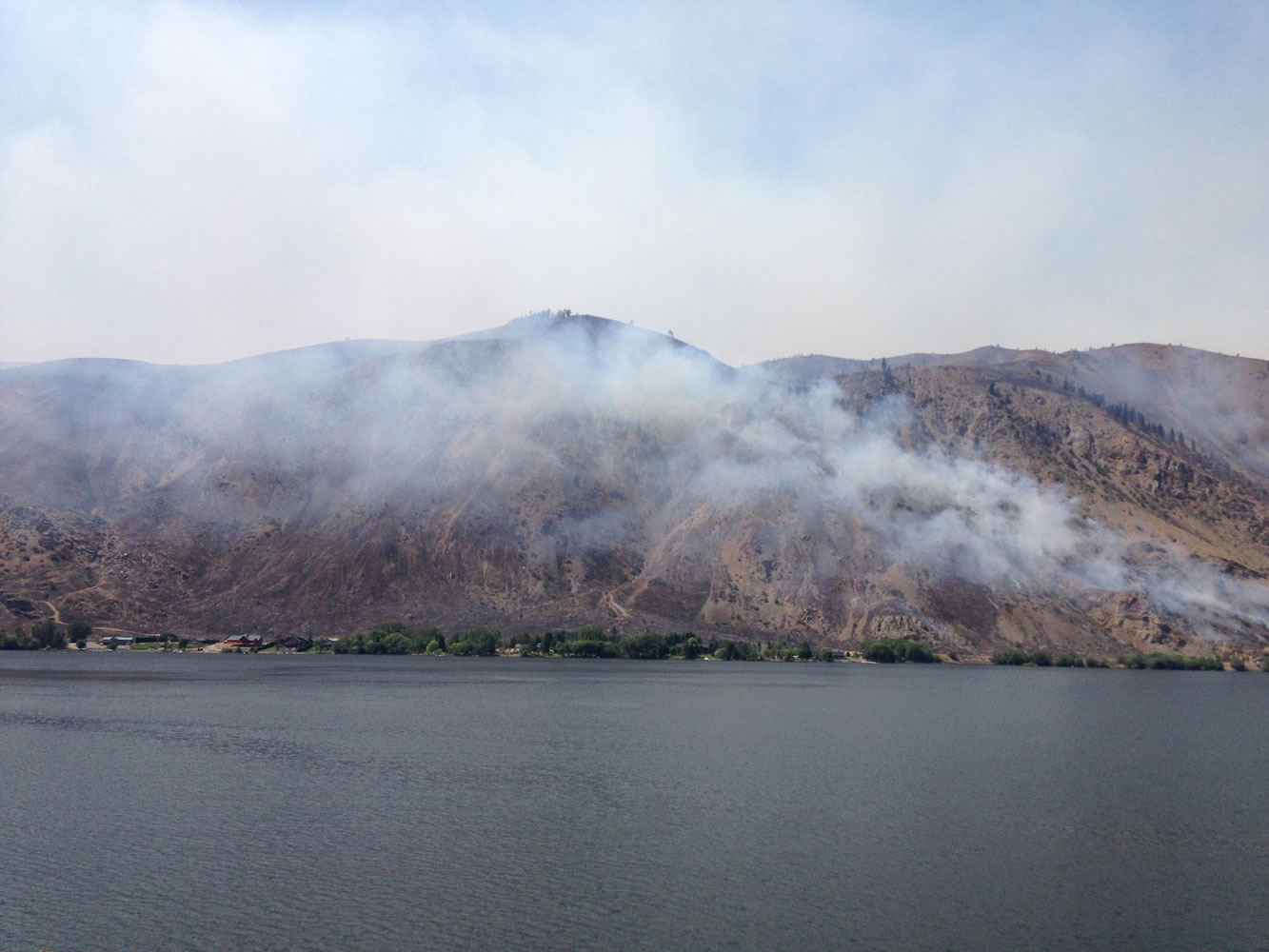 Smoke rises from the area of a wildfire near Entiat, Wash., Friday, July 11, 2014. Several hundred firefighters worked Friday to contain the fire that has burned grass and brush across nearly 30 square miles in central Washington.