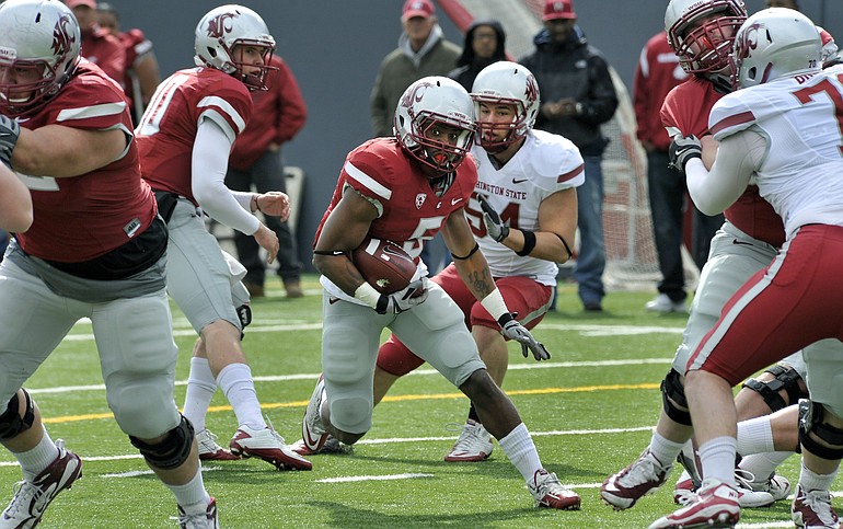 Washington State running back, Rickey Galvin (5), runs after taking a hand off from quarterback Jeff Tuel, left, during the Washington State spring football scrimmage Saturday at Joe Albi Stadium in Spokane.