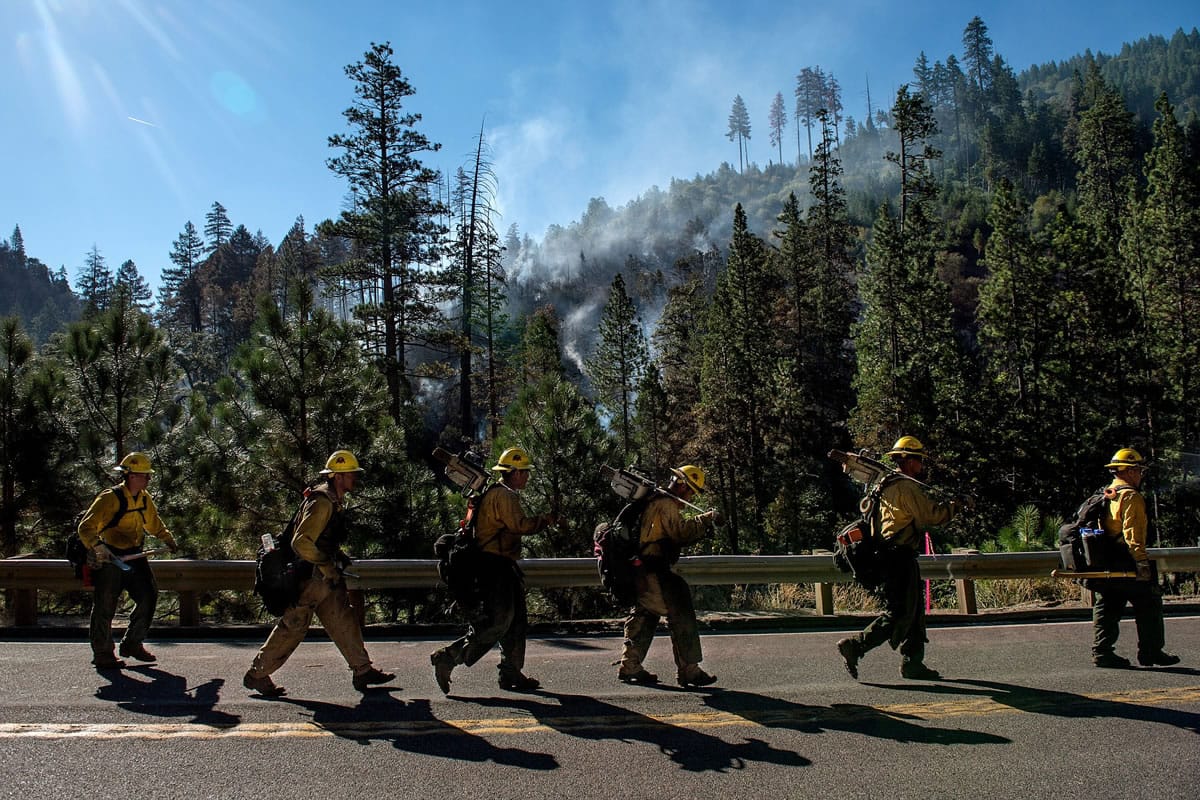 A fire unit returns to their engines as the night transitions to the day shift at the Kyburz Fire off  Highway 50 on Saturday, July 25, 2015, in El Dorado National Forest in California.