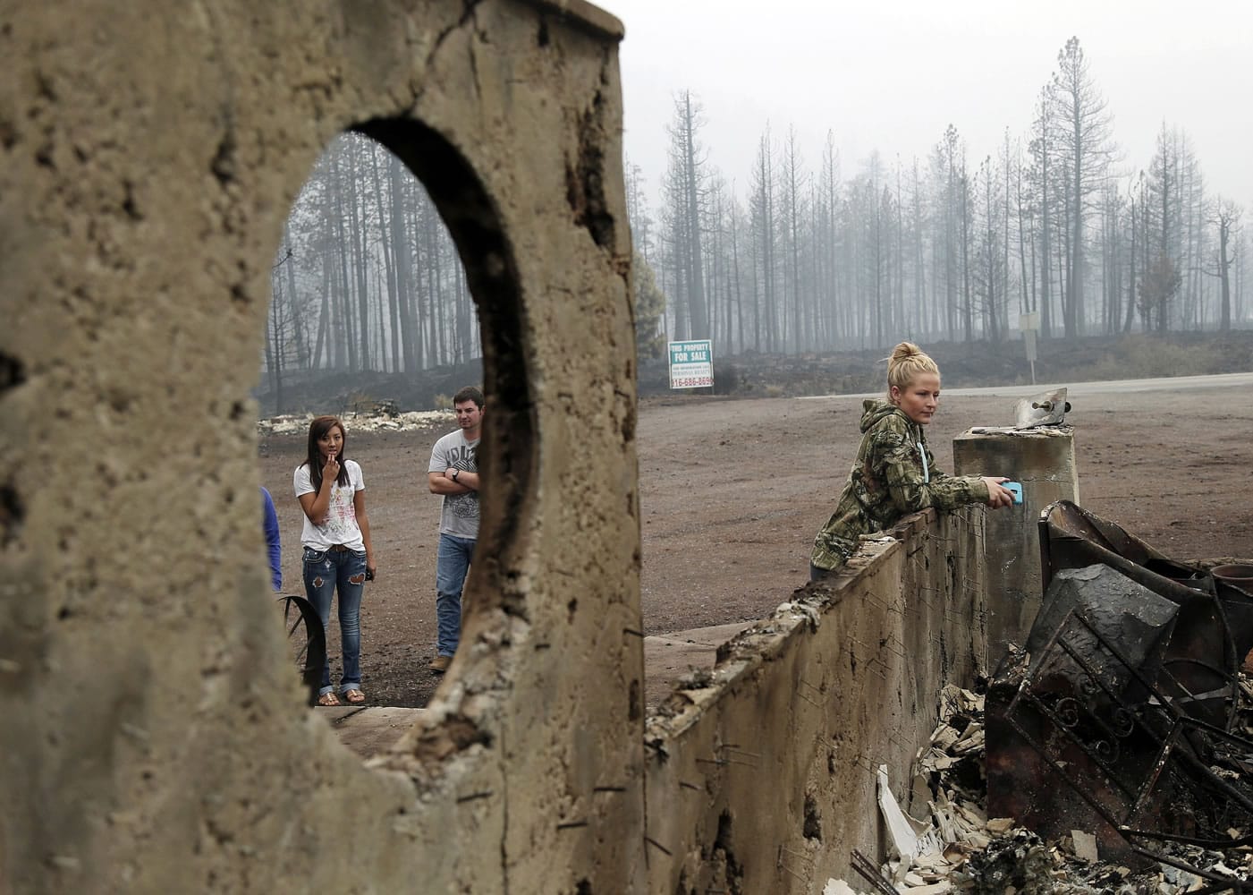Robyn Garner, right, looks at the fire-ravaged remains of the Fireside Village, a restaurant and shop owned by the Garner family, in the aftermath of the Eiler Fire on Tuesday in Hat Creek, Calif.