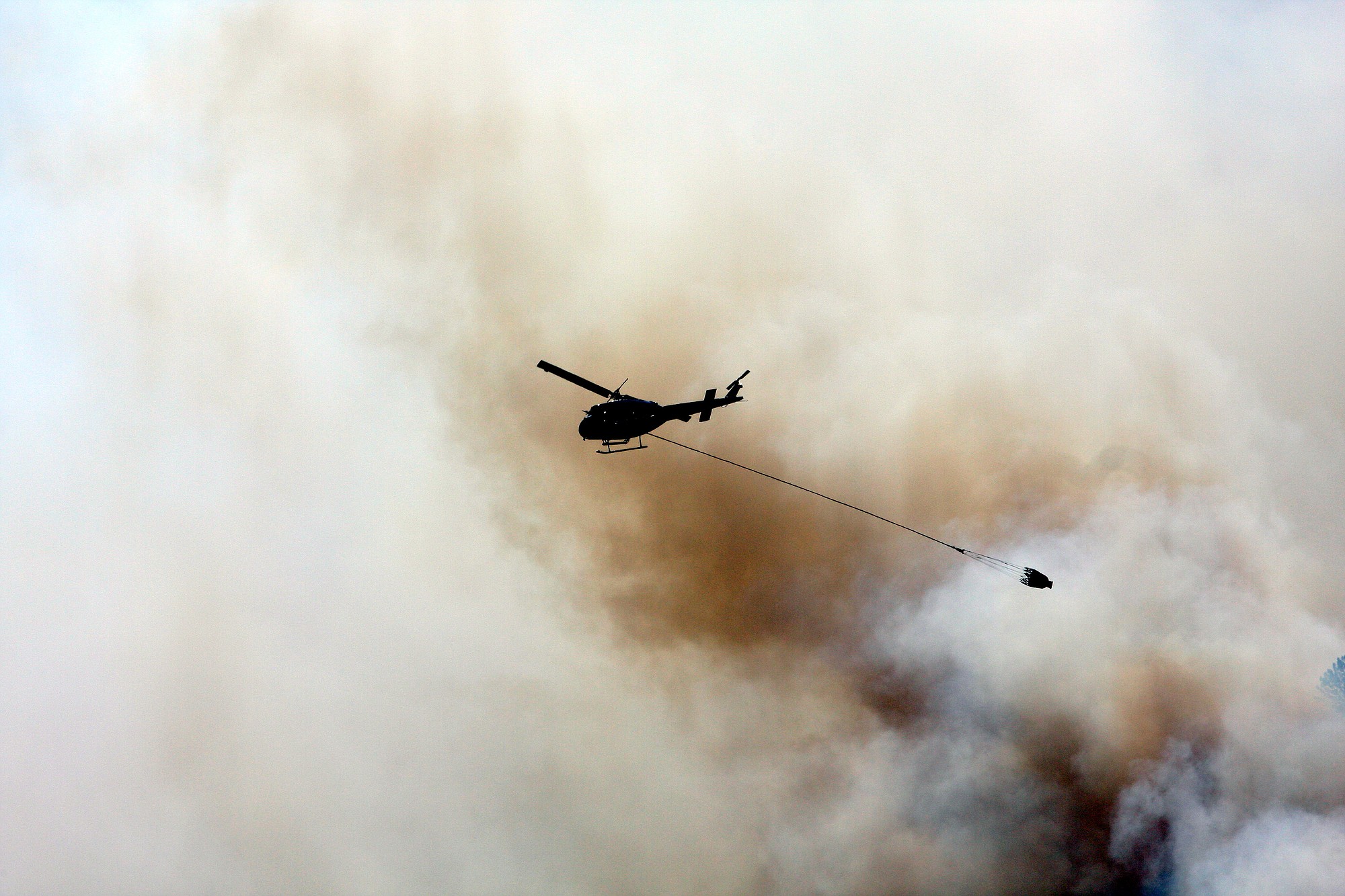 A helicopter drops water on the Rowena fire in Oregon amid high winds and dry conditions on Wednesday.