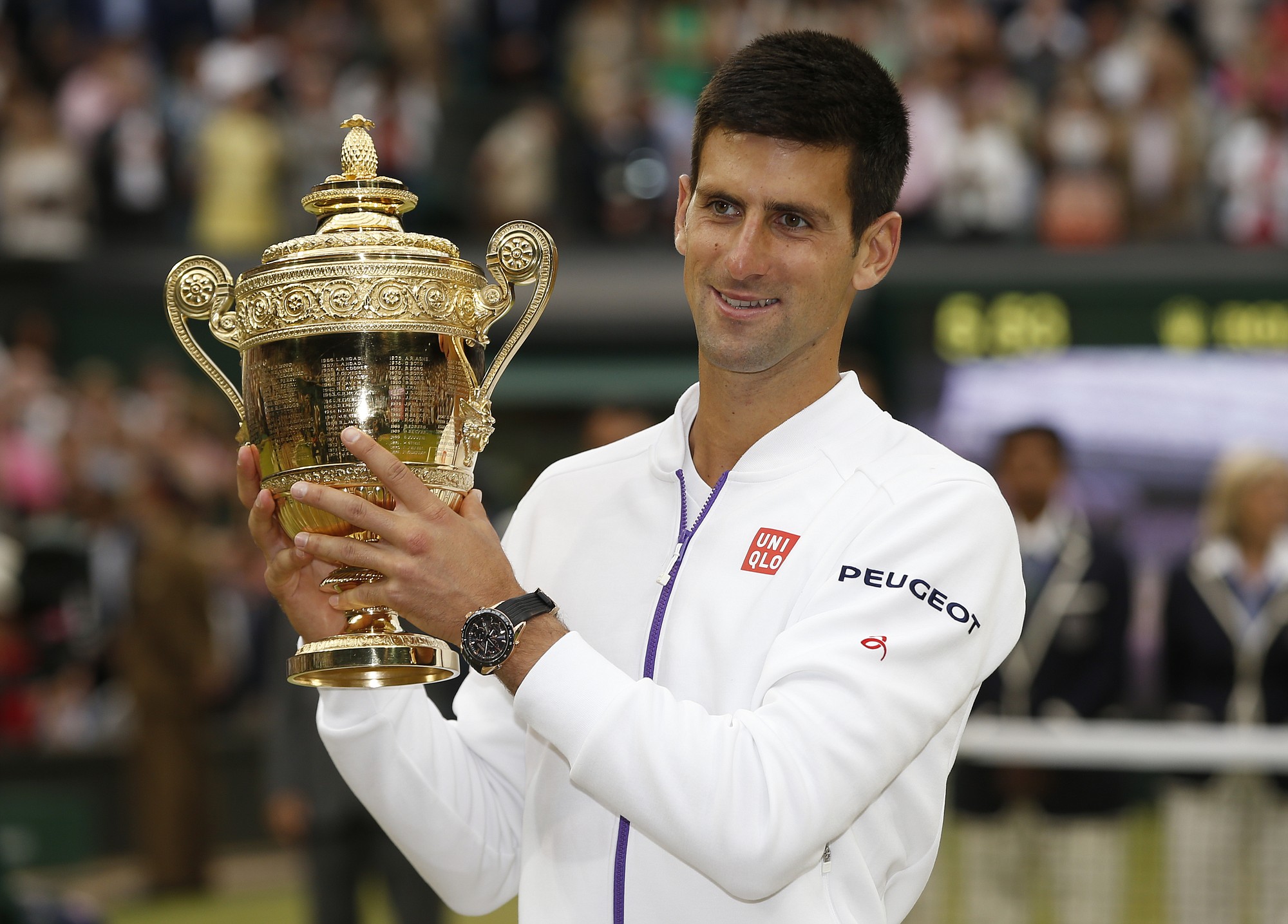 Novak Djokovic of Serbia holds the trophy after winning the men's singles final against Roger Federer of Switzerland at the All England Lawn Tennis Championships in Wimbledon, London, Sunday July 12, 2015.