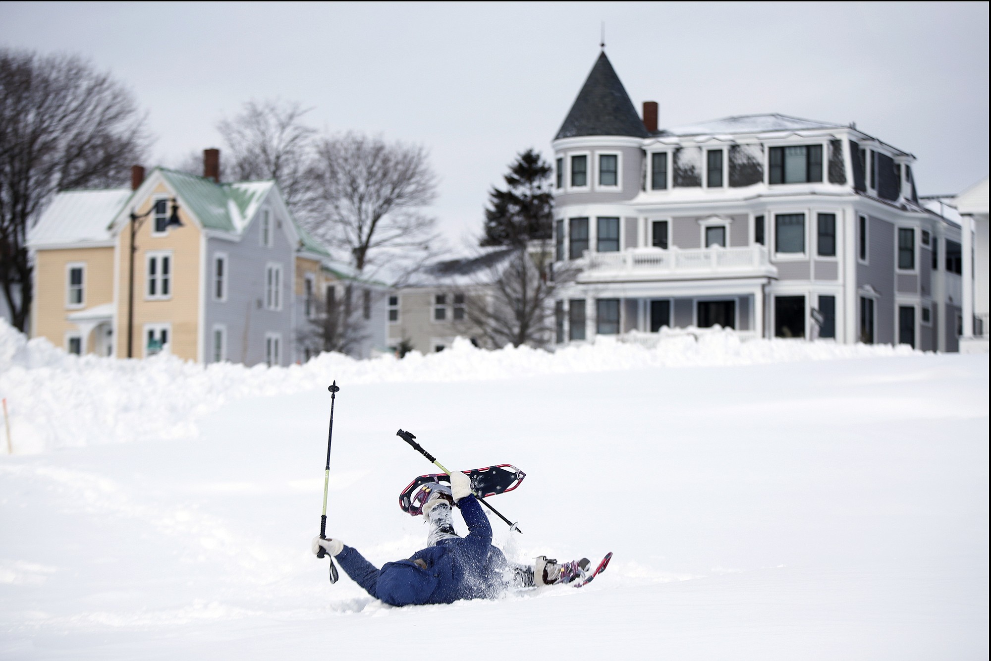 After several failed attempts to get up after falling in a deep snowdrift on the Eastern Promenade, Sandy Asmussen, 65, rolls over on her back to frees her snowshoes Wednesday in Portland, Maine.