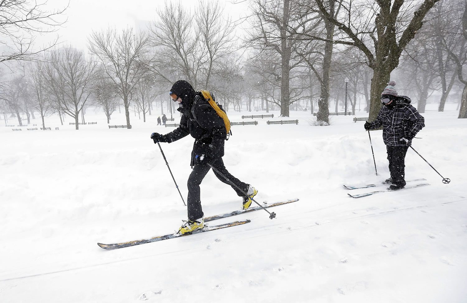 Cross-country skiers travels through the snow during a winter snowstorm Tuesday in Boston.