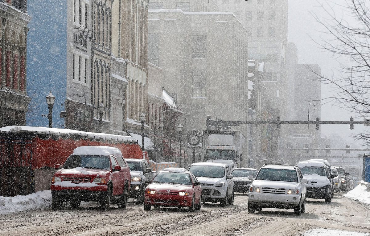 Traffic navigates West Main St. at South Upper St. during a heavy morning snow in Lexington, Ky., Wednesday Feb. 18, 2015. Low temperatures gripped the region Wednesday, freezing and refreezing the snow and ice and making the roads as hazardous as they were during the height of the storm. A major winter storm crossed Kentucky Monday with as much as 17 inches of snow reported in some spots.