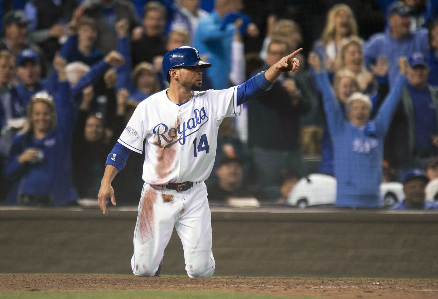 Kansas City Royals second baseman Omar Infante points after he dove past San Francisco Giants catcher Buster Posey to score in the fifth inning of Game 6 of the World Series in Kansas City, Mo.