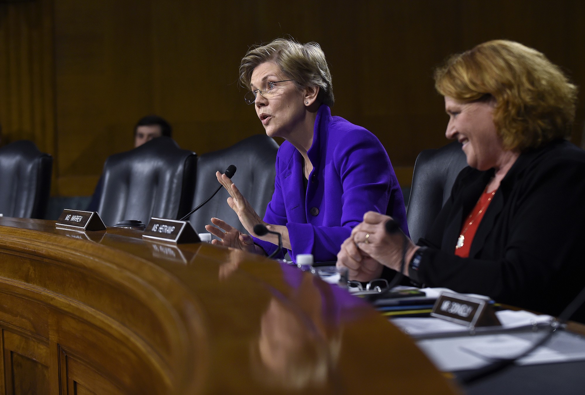 Senate Banking Committee member Sen. Heidi Heitkamp, D-N.D., listens at right as fellow committee member Sen. Elizabeth Warren, D-Mass.