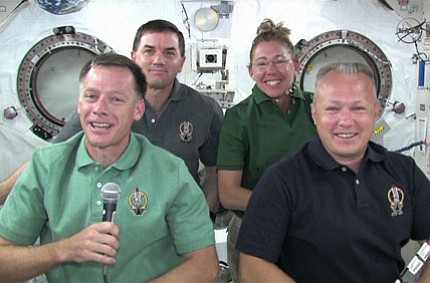 The STS-135 crew gathers in the Kibo module of the International Space Station to talk to reporters Wednesday.