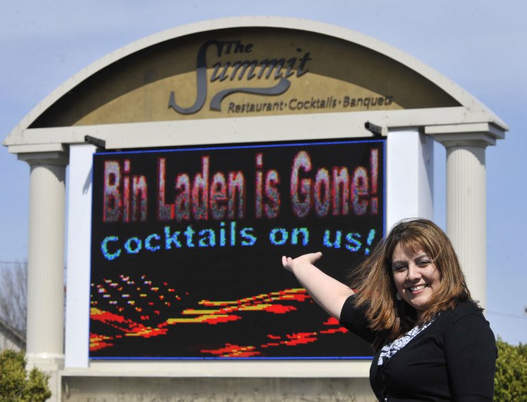 Darlene Zaragoza, the banquet manager at the Summit Restaurant in Racine Wis., shows the restaurant's sign celebrating the death of Osama bin Laden on Monday, the day after U.S.