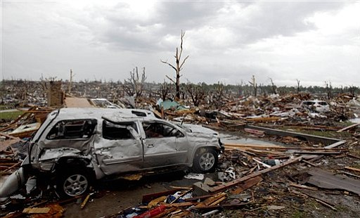 A car sits among rubble from a tornado Monday, May 23, 2011, in Joplin , Mo. A large tornado moved through much of the city Sunday, damaging a hospital and hundreds of homes and businesses.