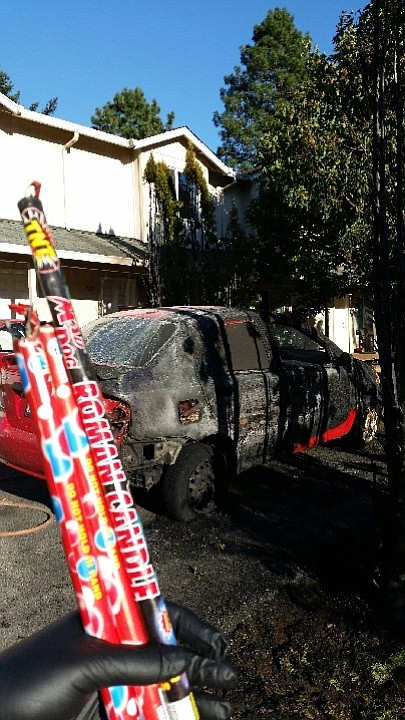 Fire officials say that a resident set of a firework that caused a blaze that destroyed one car, damaged another and nearly spread to a nearby apartment complex.