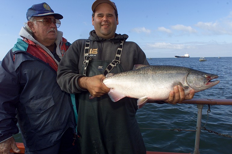 Butch Smith of Ilwaco holds a chinook caught by Dan Freil of California at Buoy 10 just inside the mouth of the Columbia River/