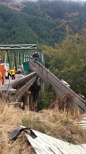 An Oregon State Police spokesman said the truck driver has been cited after a commercial truck hauling lumber products crashed at an Umpqua River bridge in southern Oregon, leaving the truck and trailer hanging over the bridge railing above the waterway. Lt. Gregg Hastings says an estimated 100 gallons of diesel leaked into the river Thursday, Sept. 18, 2014.