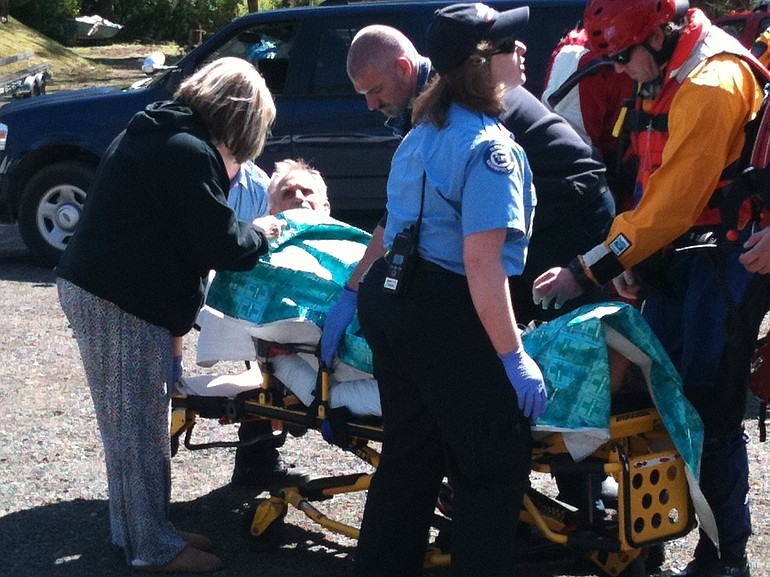 Emergency responders assist a Salem man rescued from the water in Felida Wednesday.