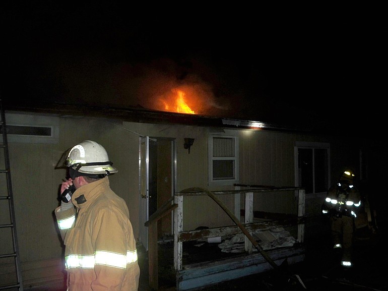 Firefighters work on a blaze at mobile home in Brush Prairie that was fully contained by 12:50 a.m.