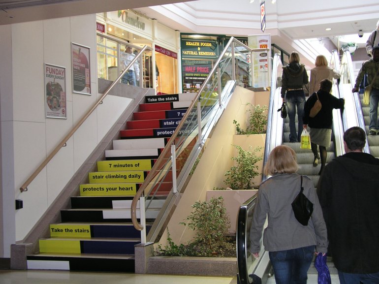 Shoppers use an escalator next to stairs at a shopping mall in Coventry, England.