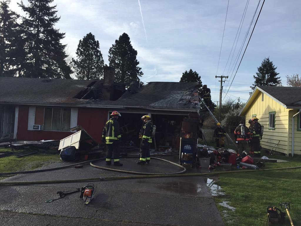 Firefighters working on the scene of a March 19, 2015 fire that caused an estimated $300,000 in damage to a home in the Ogden area of Vancouver.