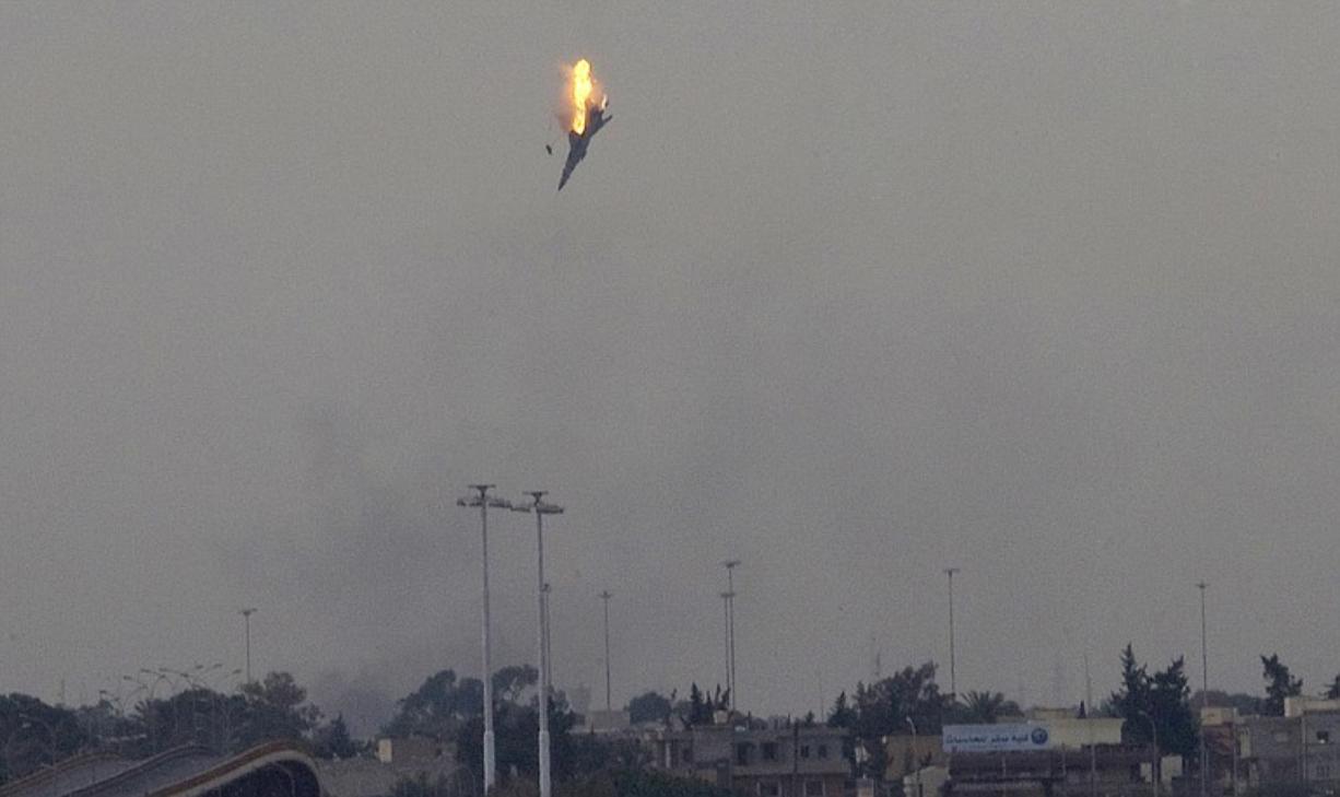 A warplane is seen being shot down over the outskirts of Benghazi, eastern Libya, on Saturday. Explosions shook the Libyan city of Benghazi early on Saturday while a Libyan jet fighter was heard flying overhead, and residents said the eastern rebel stronghold was under attack from Gadhafi's forces.