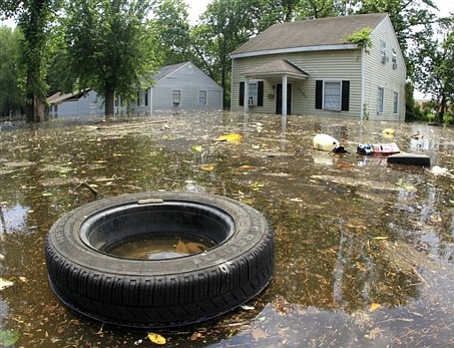 Trash floats by flooded homes on Monday, May 9, 2011, in Memphis, Tenn. The swollen Mississippi River could crest as early as Monday night.