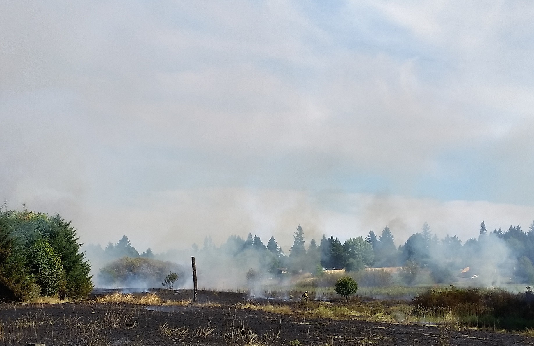 A field near the intersection of Padden Parkway and Andresen Road in Vancouver smolders after a fire Saturday.