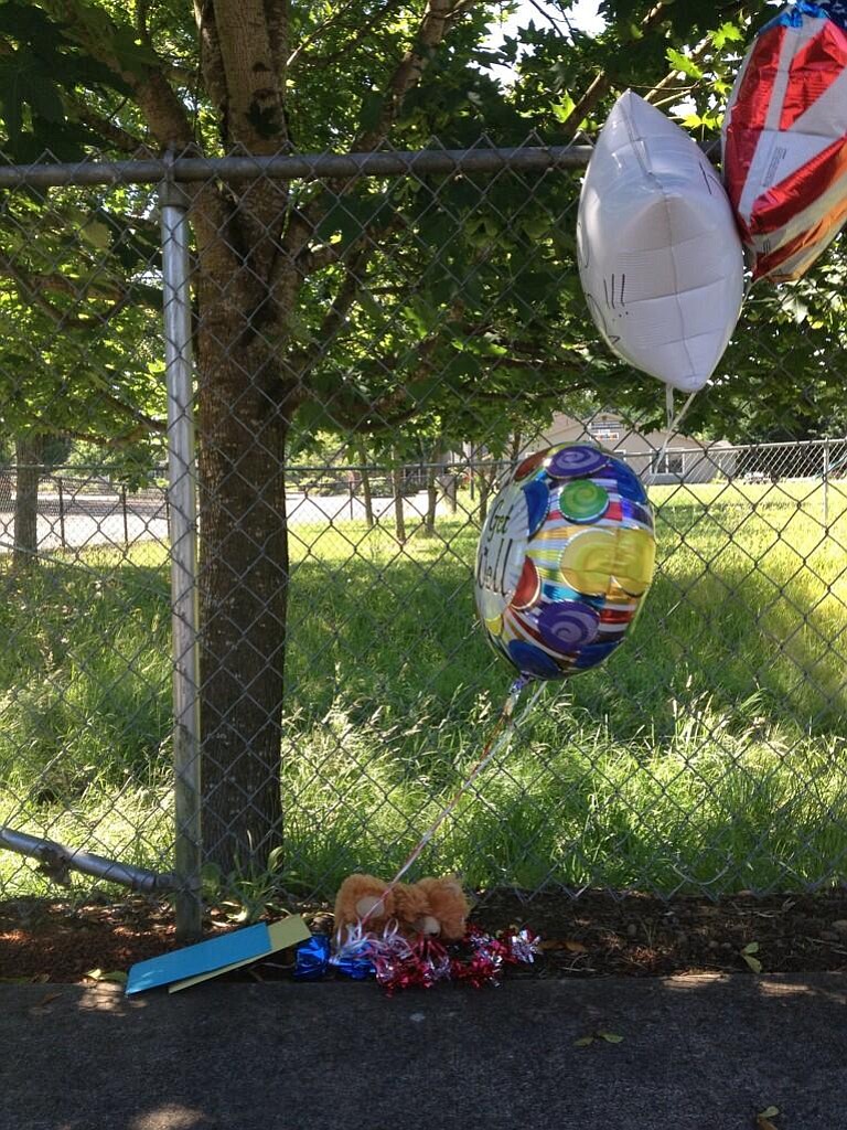 Balloons sit on the sidewalk near the location of a shooting that injured a Vancouver police officer Monday.