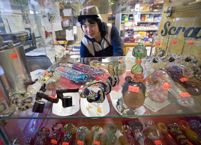 Yan Chiu, owner of Sunny Market on Northeast Minnehaha Street in Vancouver, shows a selection of glass smoking pipes that are labeled for tobacco use only.