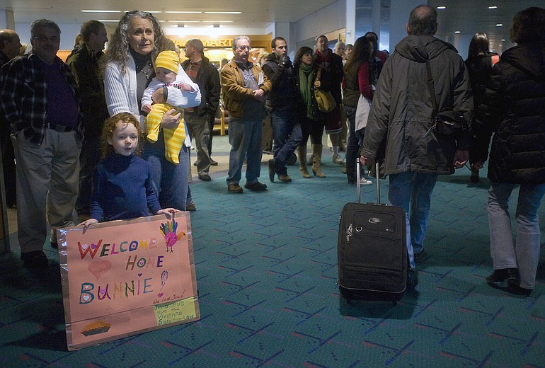 Jenavieve Boruff, left, 4, of Vancouver, holds a sign while waiting with her grandmother, Donna Knauss, of Ephrata, and sister Vivienne Boruff, 4-months, for her aunt to arrive at PDX from Tennessee on Wednesday November 24, 2010.